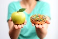 Itâs hard to choose healthy food concept, with woman hand holding an green apple and a calorie bomb donut Royalty Free Stock Photo
